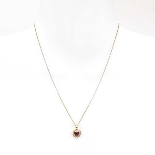 371 - A gold and garnet pendant necklace. The necklace strung with a  garnet set on a fine link chain. Cha... 