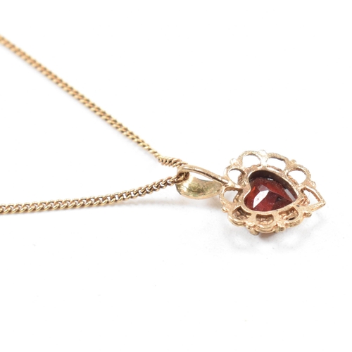 371 - A gold and garnet pendant necklace. The necklace strung with a  garnet set on a fine link chain. Cha... 