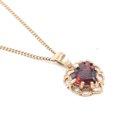 371 - A gold and garnet pendant necklace. The necklace strung with a  garnet set on a fine link chain. Cha... 