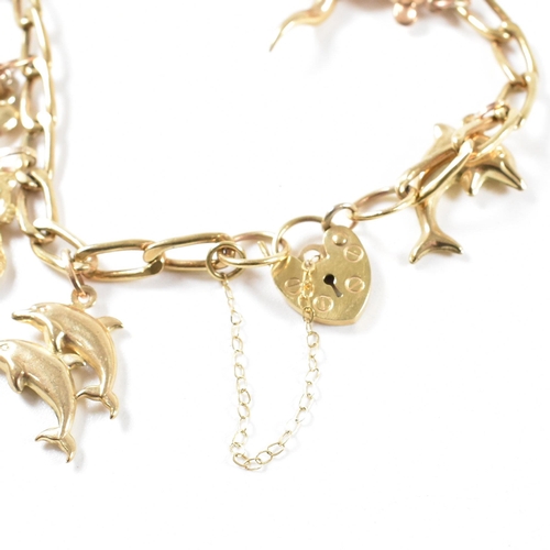 372 - A gold charm bracelet. The bracelet hallmarked to the jump ring and strung with yellow metal and gol... 