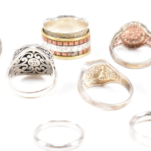 386 - A collection of 925 silver rings.The rings to include pierced, puzzle, dragonfly 18ct gold overlay, ... 