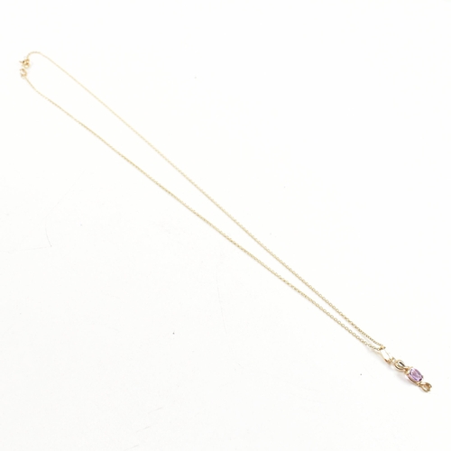 387 - A hallmarked 9ct gold pendant necklace. The necklace strung with an amethyst pendant on a fine link ... 