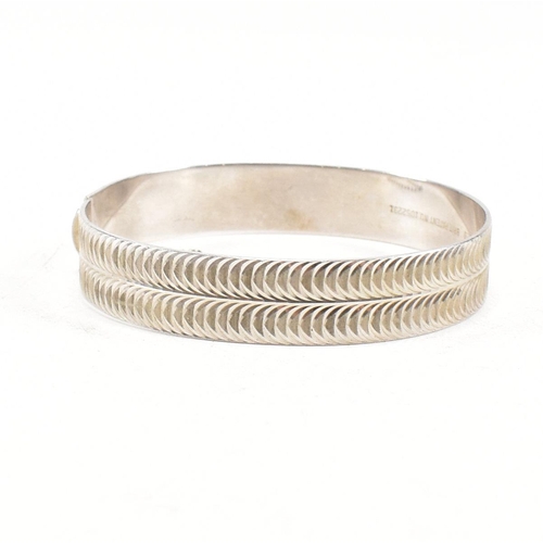 391 - Two hallmarked 925 silver hinged bangles. The bangles to include etched foliate decorated bangle, ha... 