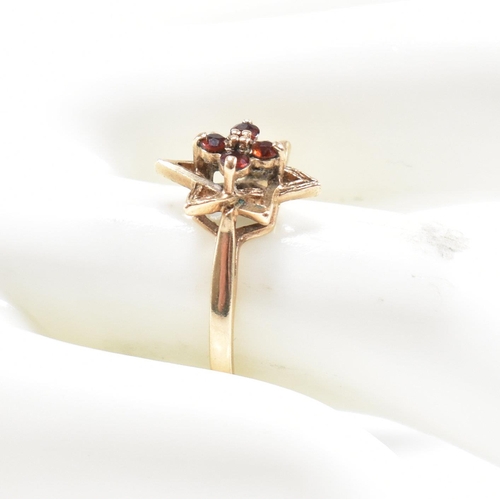 394 - A hallmarked 9ct gold garnet star cluster ring. 2.3g. Size M.5. All weights, measurements and sizes ... 