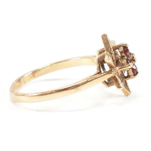 394 - A hallmarked 9ct gold garnet star cluster ring. 2.3g. Size M.5. All weights, measurements and sizes ... 