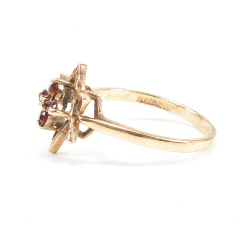 394 - A hallmarked 9ct gold garnet star cluster ring. 2.3g. Size M.5. All weights, measurements and sizes ... 