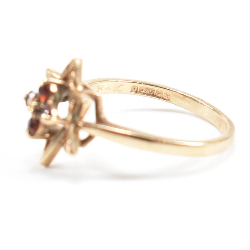 394 - A hallmarked 9ct gold garnet star cluster ring. 2.3g. Size M.5. All weights, measurements and sizes ... 