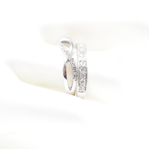 40 - Two hallmarked 9ct white gold and diamond rings. A half eternity ring and diamond set swirl ring. We... 