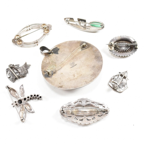 400 - A collection of silver brooch pins. The brooches to include a Mexican brooch pendant, dragonfly, tal... 