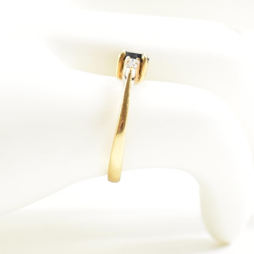 452 - A gold sapphire and diamond five stone ring. The ring set with a central sapphire flanked by four di... 