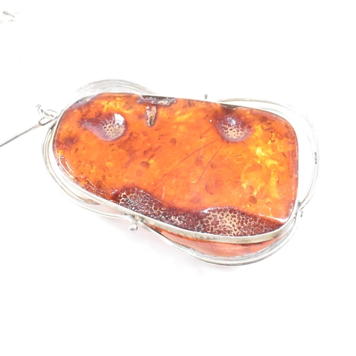 454 - A white metal and amber pendant necklace together with an amber and resin set hinged bangle and a gr... 