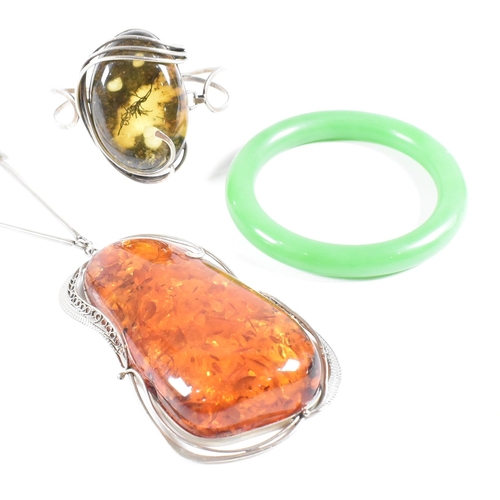 454 - A white metal and amber pendant necklace together with an amber and resin set hinged bangle and a gr... 