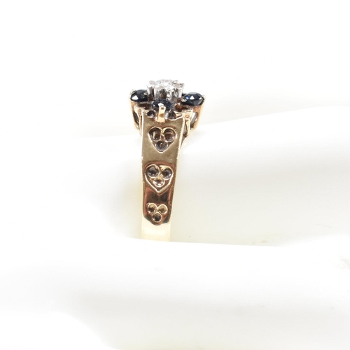 495 - A hallmarked 9ct gold sapphire and diamond cluster ring having heart decorated shoulders. Weight 2.8... 