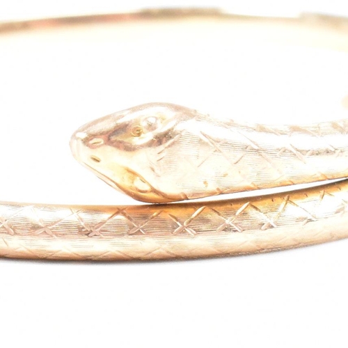 8 - A hallmarked 9ct gold snake bangle. The bangle in the form of a coiled snake. Hallmarked Birmingham.... 