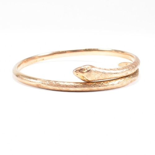 8 - A hallmarked 9ct gold snake bangle. The bangle in the form of a coiled snake. Hallmarked Birmingham.... 