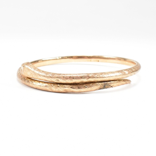 8 - A hallmarked 9ct gold snake bangle. The bangle in the form of a coiled snake. Hallmarked Birmingham.... 