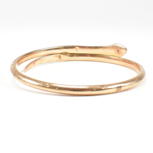 8 - A hallmarked 9ct gold snake bangle. The bangle in the form of a coiled snake. Hallmarked Birmingham.... 