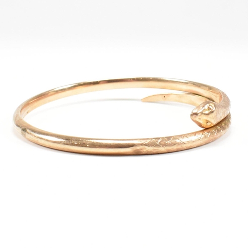 8 - A hallmarked 9ct gold snake bangle. The bangle in the form of a coiled snake. Hallmarked Birmingham.... 