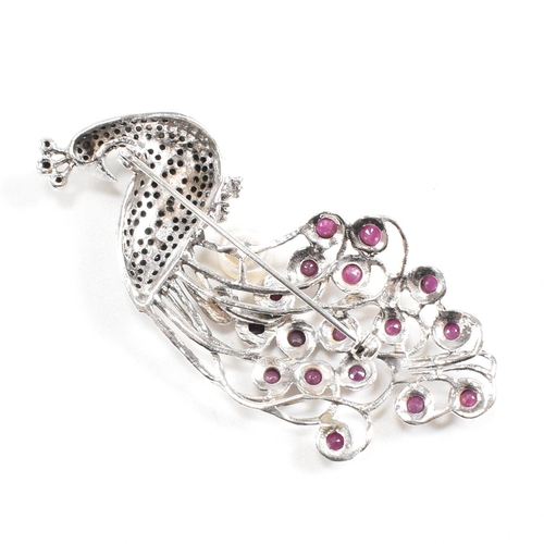 81 - A contemporary 925 silver marcasite peacock brooch set with garnets. Weight approx 16g. Measures app... 