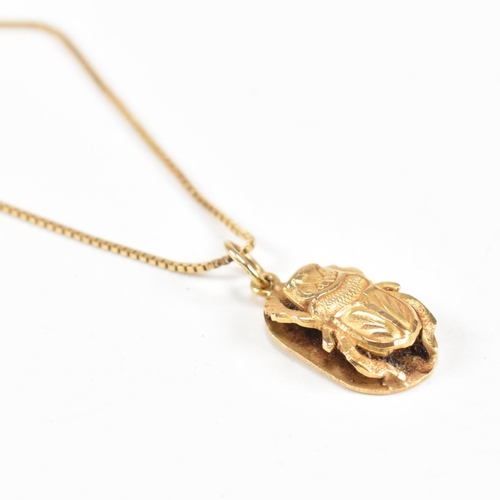 87 - An 18ct gold Scarab pendant necklace. The fine box chain strung with a scarab beetle pendant. The ch... 