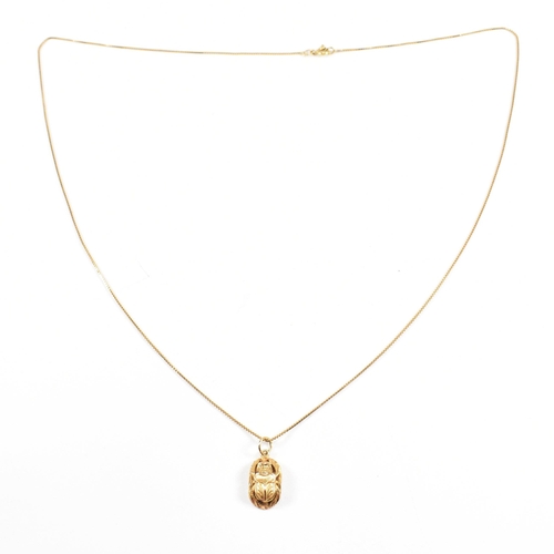 87 - An 18ct gold Scarab pendant necklace. The fine box chain strung with a scarab beetle pendant. The ch... 