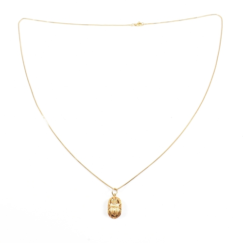 87 - An 18ct gold Scarab pendant necklace. The fine box chain strung with a scarab beetle pendant. The ch... 