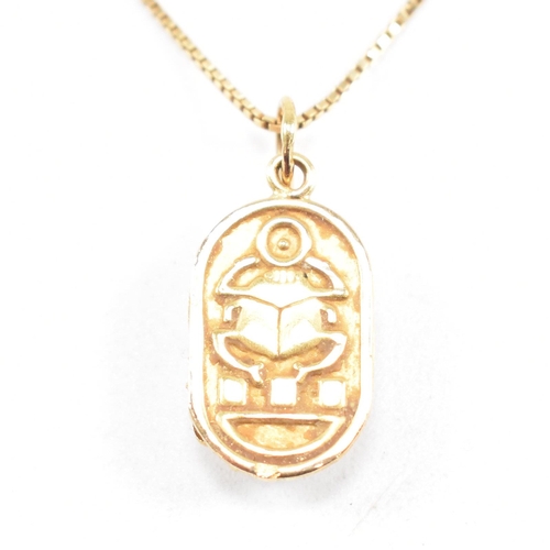 87 - An 18ct gold Scarab pendant necklace. The fine box chain strung with a scarab beetle pendant. The ch... 