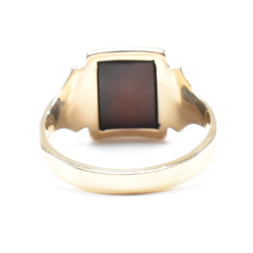 180 - A 9ct gold and sard signet ring. The ring set with rectangular sard plaque to a wide band shank. Unm... 