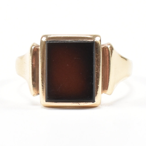 180 - A 9ct gold and sard signet ring. The ring set with rectangular sard plaque to a wide band shank. Unm... 