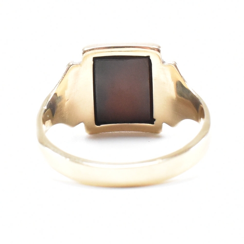 180 - A 9ct gold and sard signet ring. The ring set with rectangular sard plaque to a wide band shank. Unm... 