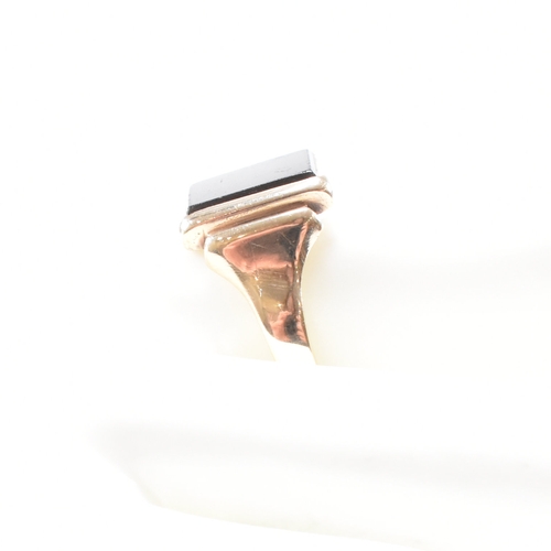 180 - A 9ct gold and sard signet ring. The ring set with rectangular sard plaque to a wide band shank. Unm... 