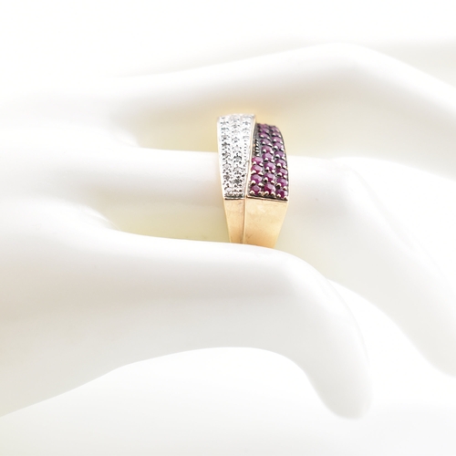 333 - A hallmarked 9ct yellow ruby & diamond cluster ring. The ring having an undulating crossover style r... 