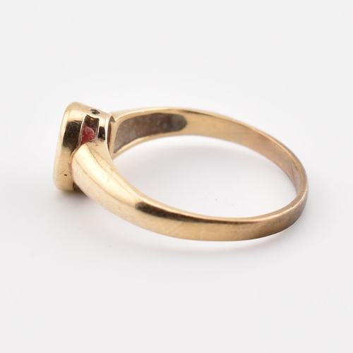 359 - A hallmarked 9ct yellow gold & red stone solitaire ring. The single stone ring having an oval cut be... 