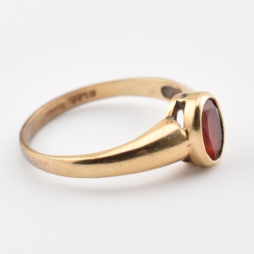 359 - A hallmarked 9ct yellow gold & red stone solitaire ring. The single stone ring having an oval cut be... 