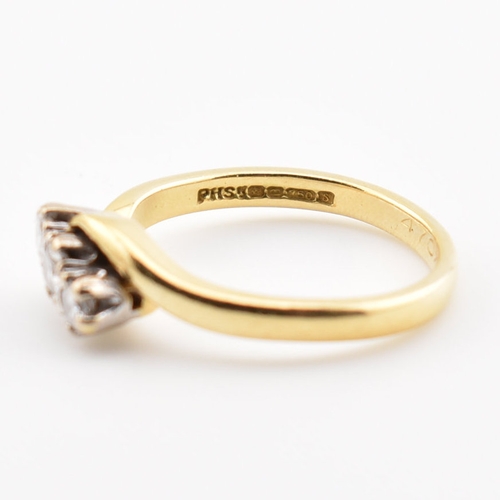 368 - A hallmarked 18ct yellow gold & diamond crossover ring. The ring having three round cut graduating d... 