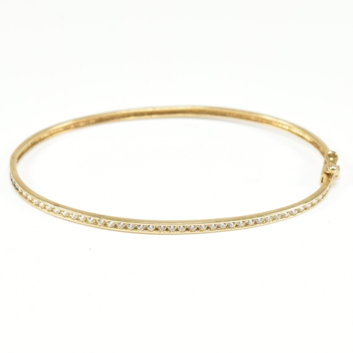 381 - A vintage 9ct yellow gold & white stone bangle bracelet. The hinged half eternity style bangle havin... 