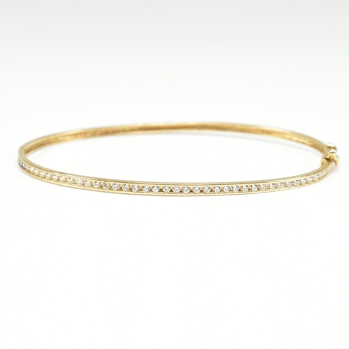 381 - A vintage 9ct yellow gold & white stone bangle bracelet. The hinged half eternity style bangle havin... 