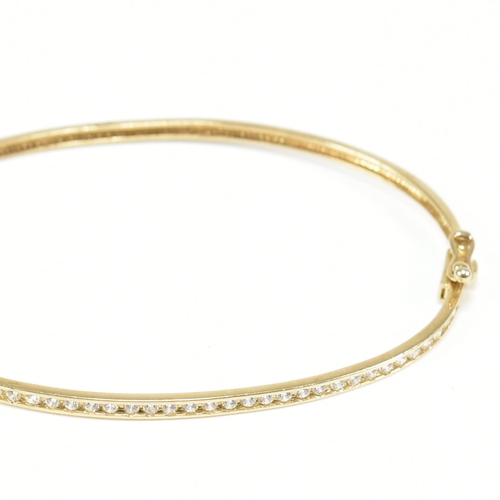 381 - A vintage 9ct yellow gold & white stone bangle bracelet. The hinged half eternity style bangle havin... 