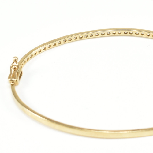 381 - A vintage 9ct yellow gold & white stone bangle bracelet. The hinged half eternity style bangle havin... 