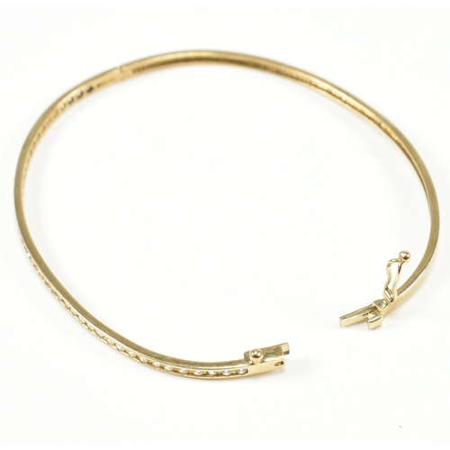 381 - A vintage 9ct yellow gold & white stone bangle bracelet. The hinged half eternity style bangle havin... 