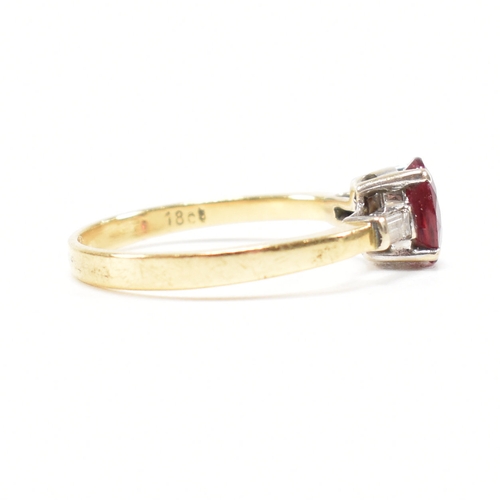 403 - An 18ct gold ruby and diamond ring. The ring set with a central claw mounted ruby and flanked by a p... 