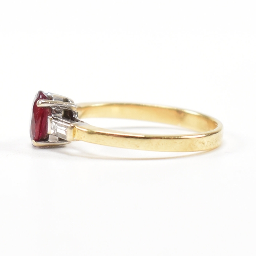 403 - An 18ct gold ruby and diamond ring. The ring set with a central claw mounted ruby and flanked by a p... 