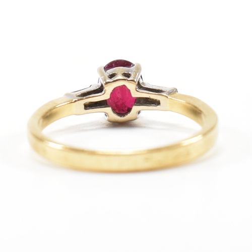 403 - An 18ct gold ruby and diamond ring. The ring set with a central claw mounted ruby and flanked by a p... 