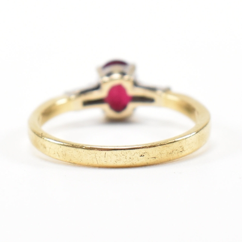 403 - An 18ct gold ruby and diamond ring. The ring set with a central claw mounted ruby and flanked by a p... 