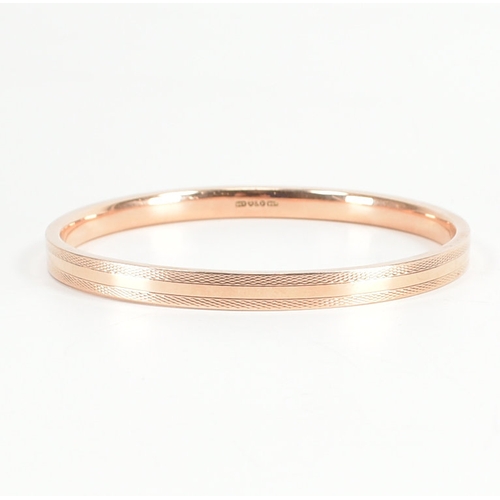 480 - A 9ct rose gold etched design bangle armlet. The bracelet / arm band of circular reverse D form havi... 