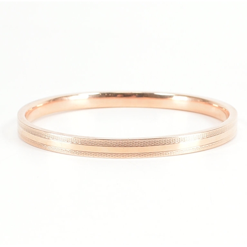 480 - A 9ct rose gold etched design bangle armlet. The bracelet / arm band of circular reverse D form havi... 