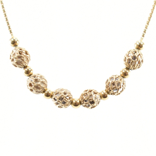 482 - An 18ct gold beaded necklace chain. The having box links with six pierced gold beads to the centre. ... 