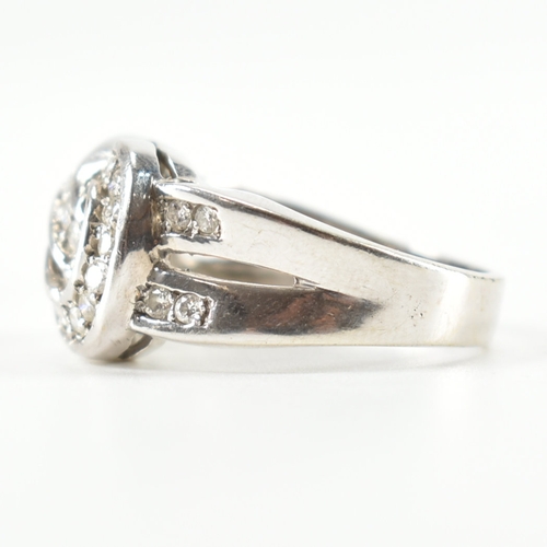 490 - A hallmarked 9ct white gold and diamond knot design ring. The ring being set throughout with round c... 