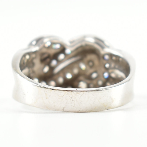 490 - A hallmarked 9ct white gold and diamond knot design ring. The ring being set throughout with round c... 