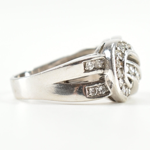 490 - A hallmarked 9ct white gold and diamond knot design ring. The ring being set throughout with round c... 